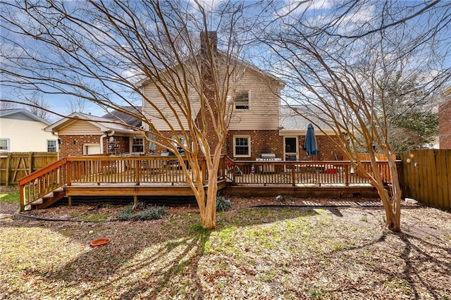 back of house with fence private yard, a deck, and brick siding