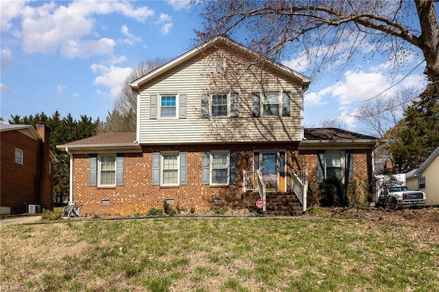 view of front of home featuring brick siding, crawl space, and a front lawn