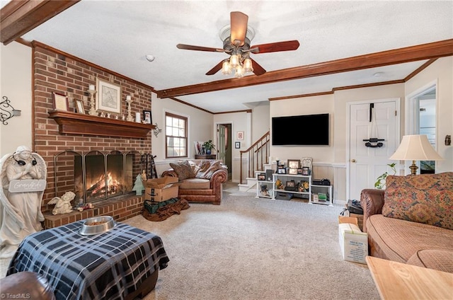 carpeted living area with ornamental molding, stairs, a textured ceiling, a brick fireplace, and beam ceiling