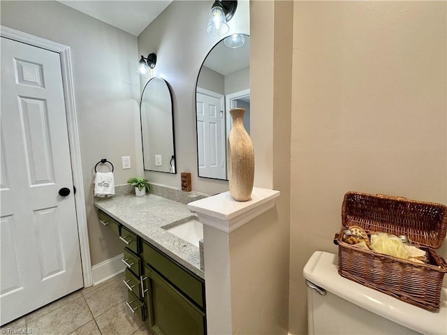 half bath featuring vanity, tile patterned floors, and toilet