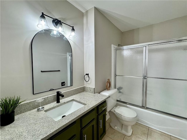 bathroom featuring tile patterned floors, toilet, vanity, and shower / bath combination with glass door