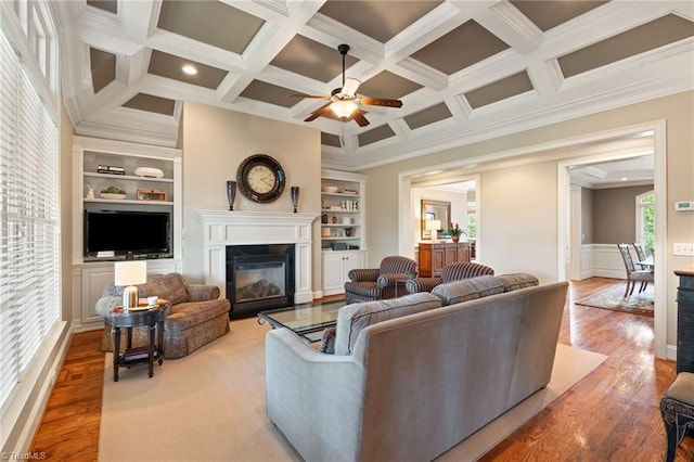 5459 Brookberry Farm Rd, Winston-Salem, NC 27106 - living room with a ceiling fan, coffered ceiling, wood finished floors, crown molding, and a glass covered fireplace