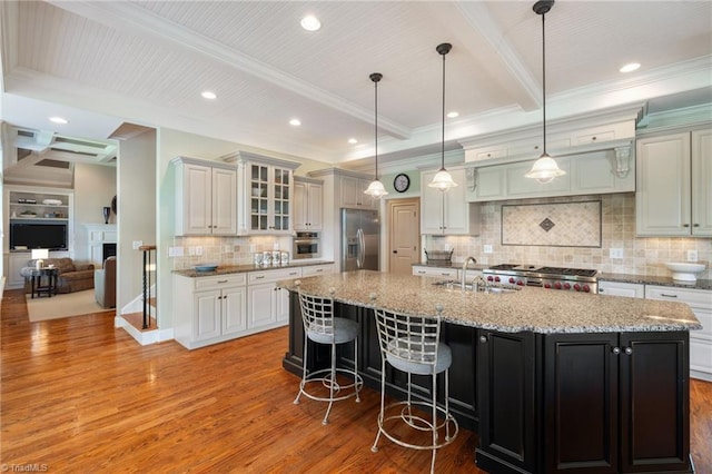 5459 Brookberry Farm Rd, Winston-Salem, NC 27106 - kitchen with stainless steel appliances, light wood-type flooring, a sink, beam ceiling, and a large island with sink