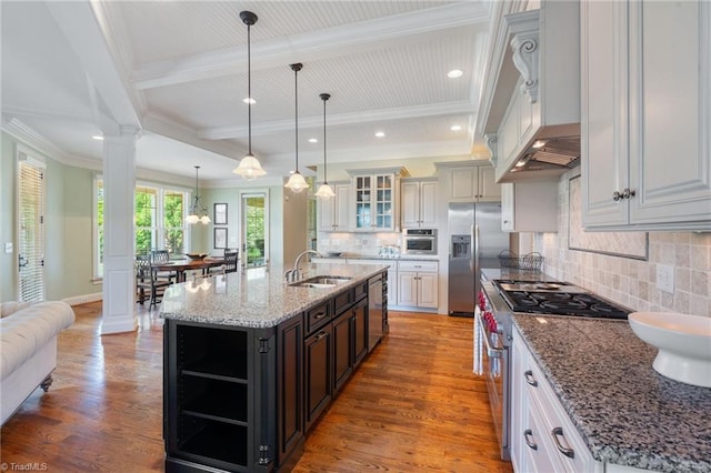 5459 Brookberry Farm Rd, Winston-Salem, NC 27106 - kitchen featuring appliances with stainless steel finishes, a sink, ornate columns, glass insert cabinets, and wood finished floors
