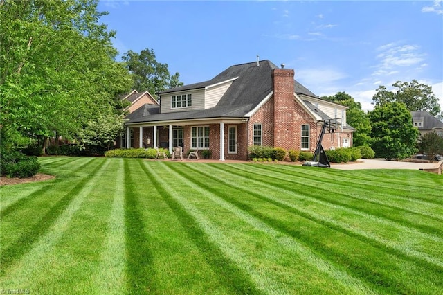 5459 Brookberry Farm Rd, Winston-Salem, NC 27106 - back of property with a lawn, a chimney, and brick siding