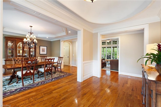 5459 Brookberry Farm Rd, Winston-Salem, NC 27106 - dining room featuring wood finished floors, a raised ceiling, ornamental molding, a chandelier, and a wainscoted wall