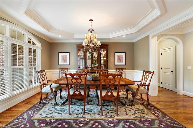 5459 Brookberry Farm Rd, Winston-Salem, NC 27106 - dining room featuring a raised ceiling, light wood-style floors, a chandelier, crown molding, and wainscoting