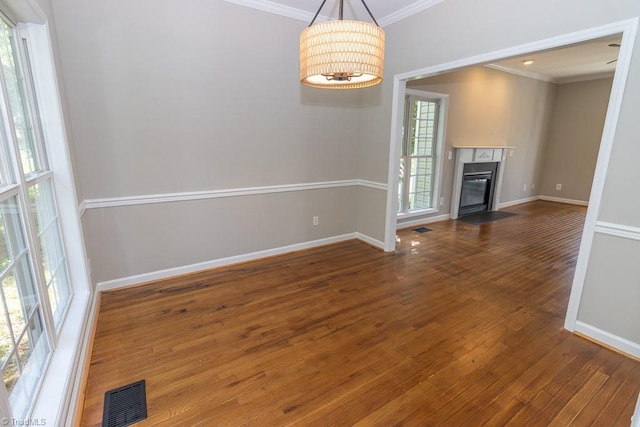 7905 Cress Ct, Oak Ridge, NC 27310 - unfurnished living room with crown molding, healthy amount of natural light, wood finished floors, baseboards, and a fireplace with flush hearth