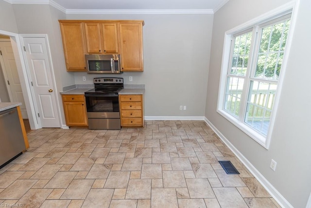7905 Cress Ct, Oak Ridge, NC 27310 - kitchen with appliances with stainless steel finishes, stone finish flooring, light countertops, healthy amount of natural light, and crown molding