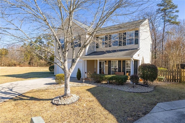 front facade featuring a garage, a front yard, and covered porch