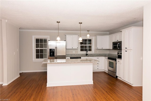 kitchen with stainless steel appliances, dark wood-style flooring, a kitchen island, white cabinets, and ornamental molding