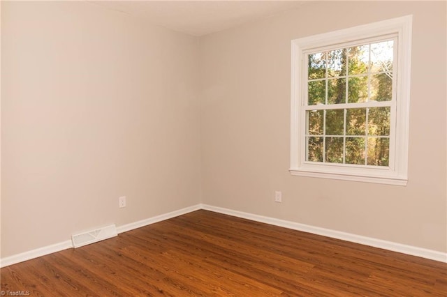 spare room with dark wood-style flooring and baseboards