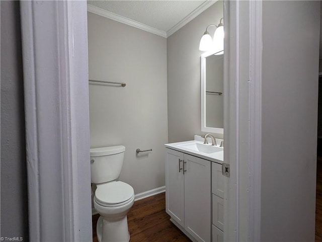 bathroom featuring ornamental molding, vanity, wood finished floors, toilet, and baseboards