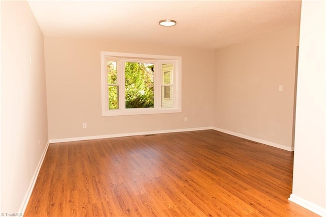 empty room with wood finished floors and baseboards