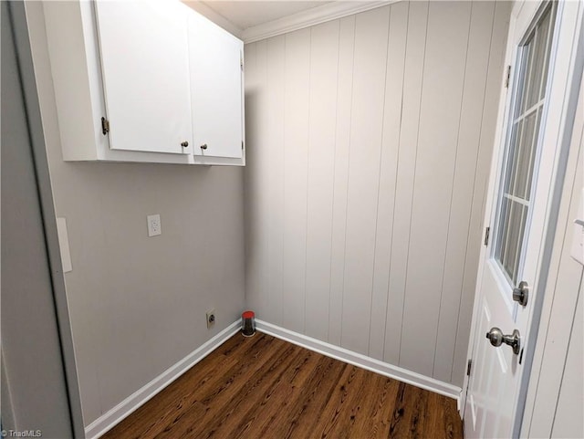 laundry room with cabinets, hookup for an electric dryer, dark hardwood / wood-style floors, wooden walls, and ornamental molding