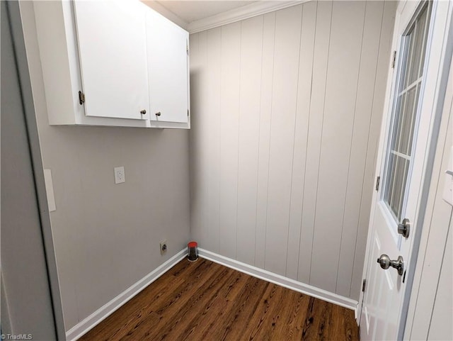 clothes washing area with cabinet space, electric dryer hookup, dark wood finished floors, and baseboards