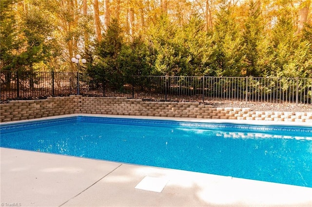 view of swimming pool featuring fence