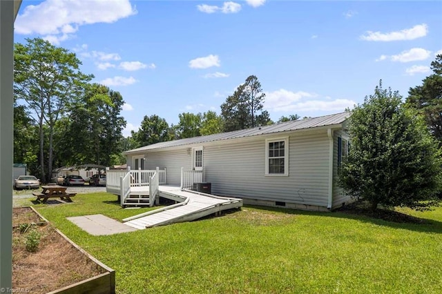 207 Bingham St, Carthage, NC 28327 - rear view of house with a wooden deck, crawl space, metal roof, and a lawn