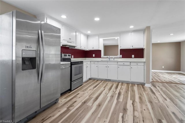 207 Bingham St, Carthage, NC 28327 - kitchen featuring stainless steel appliances, under cabinet range hood, light wood-style floors, white cabinetry, and recessed lighting