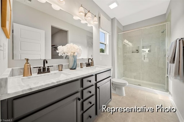 bathroom featuring double vanity, a shower stall, and a sink