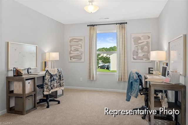 home office with baseboards and light colored carpet