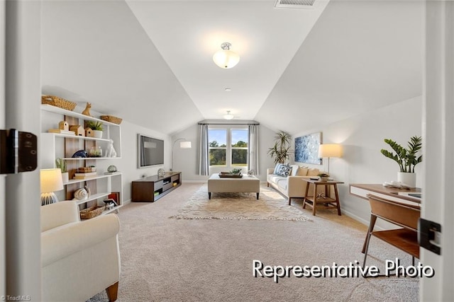 sitting room with lofted ceiling, light colored carpet, visible vents, and baseboards