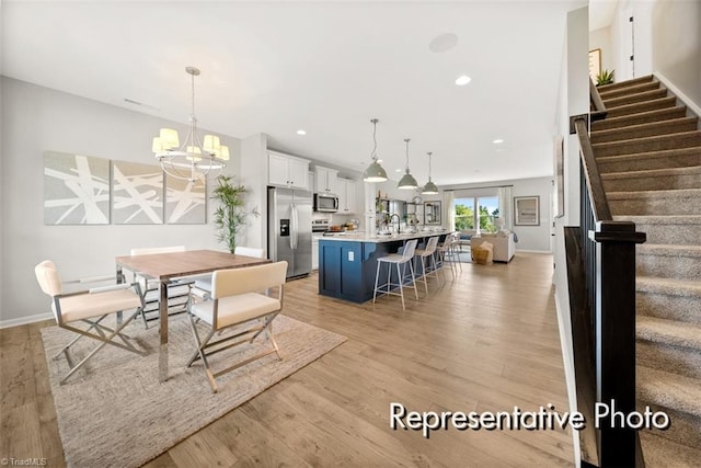 dining space featuring recessed lighting, an inviting chandelier, light wood-type flooring, baseboards, and stairs