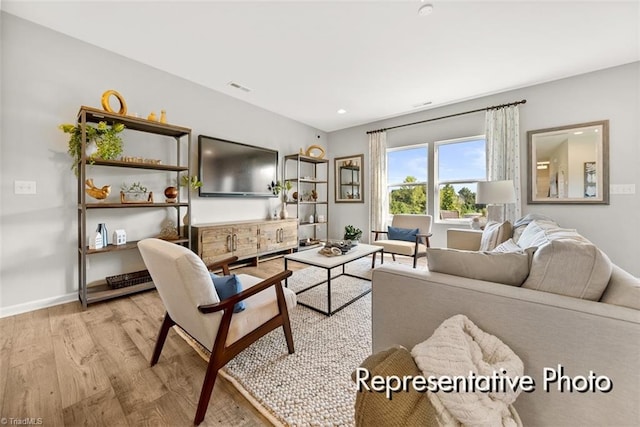 living room with light wood finished floors, recessed lighting, visible vents, and baseboards