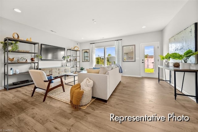 living area with recessed lighting, baseboards, and light wood finished floors