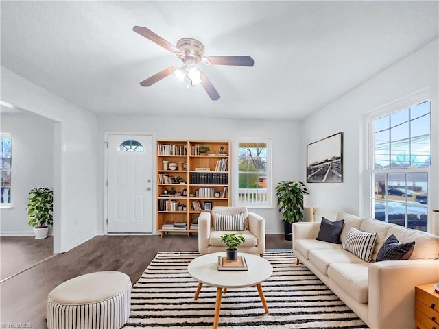 living area with a ceiling fan and baseboards