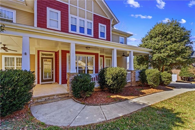 view of exterior entry featuring covered porch and ceiling fan