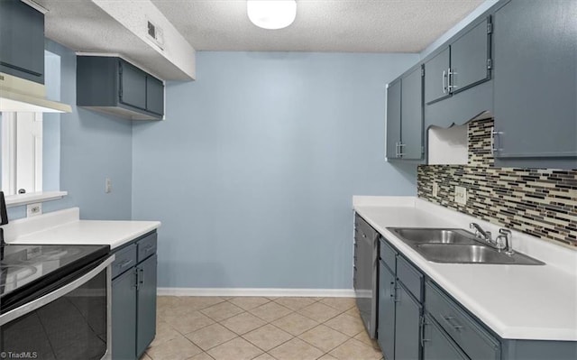 kitchen with a textured ceiling, stainless steel appliances, backsplash, and sink