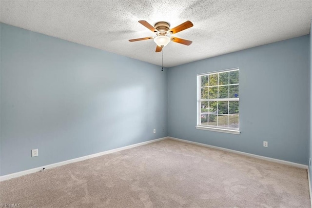 empty room featuring a textured ceiling, ceiling fan, and light colored carpet