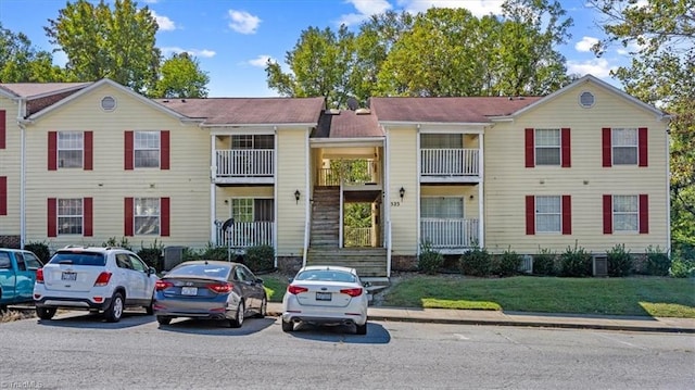 townhome / multi-family property featuring a balcony and a front lawn