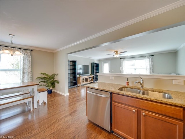 kitchen with light wood-type flooring, stainless steel dishwasher, light stone counters, and sink