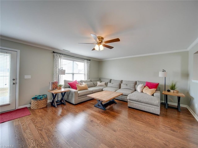 living room with a wealth of natural light, wood-type flooring, and ornamental molding