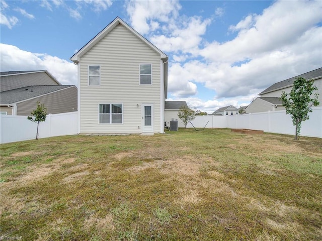 back of property with central air condition unit and a yard