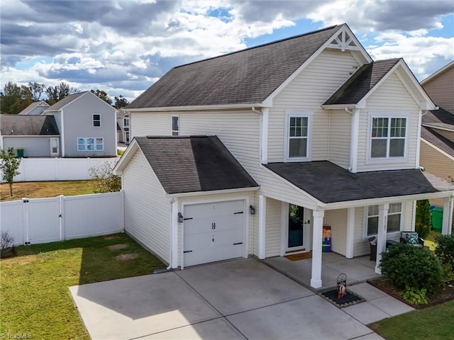 view of front of house featuring a garage, a front yard, and a porch