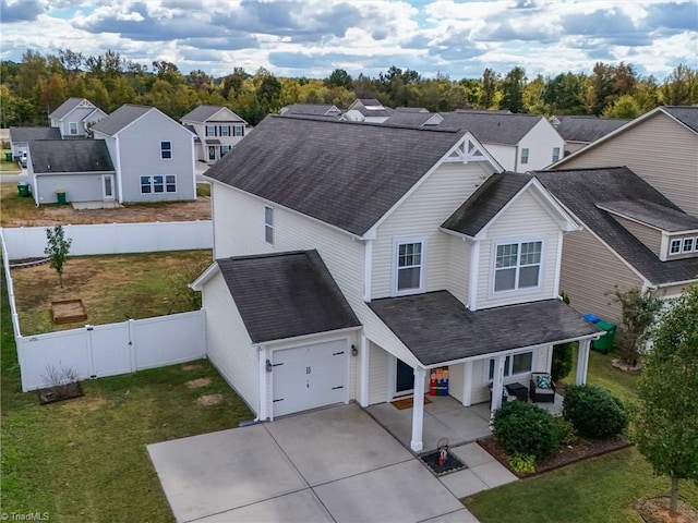 view of front of house featuring a porch, a front lawn, and a garage