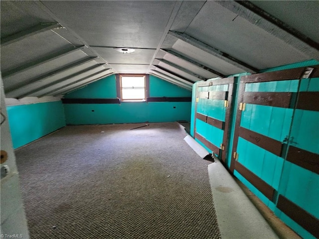 additional living space featuring lofted ceiling and carpet flooring