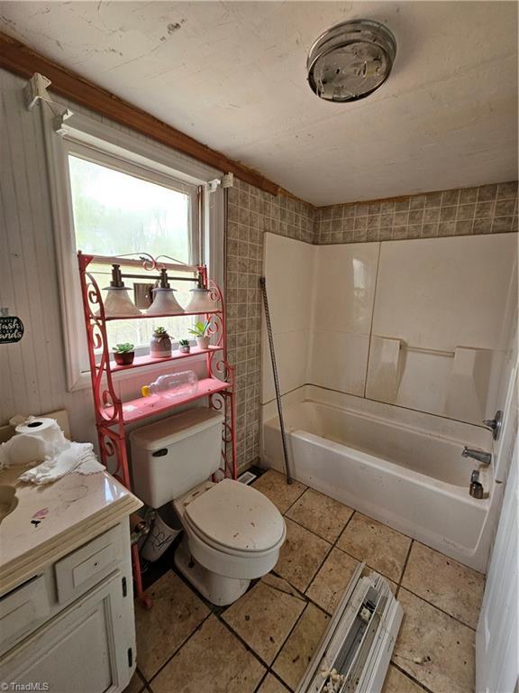 full bath with toilet, vanity, and bathing tub / shower combination