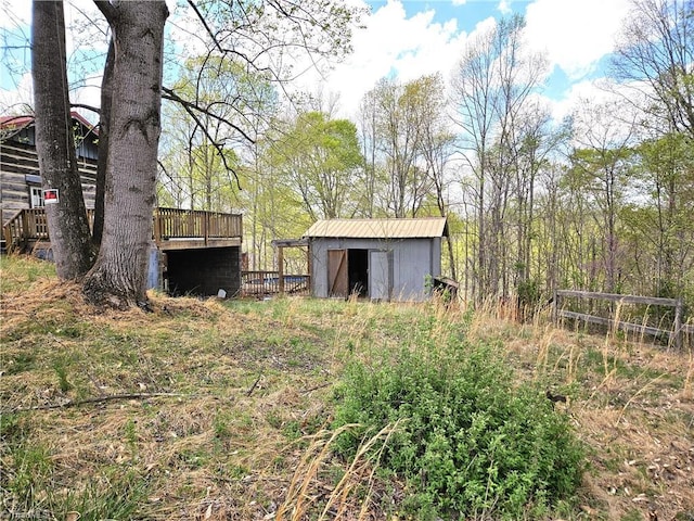 view of yard featuring a storage unit, a wooden deck, and an outdoor structure