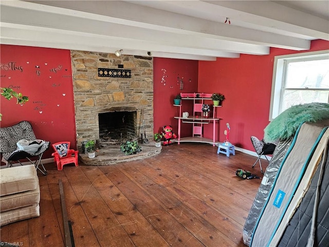 living room with baseboards, a fireplace, beam ceiling, and hardwood / wood-style floors