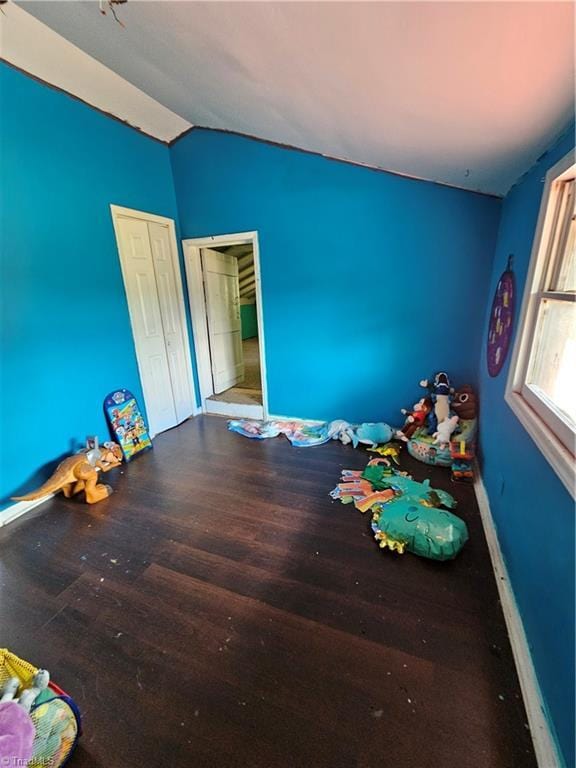 unfurnished bedroom with lofted ceiling and wood finished floors
