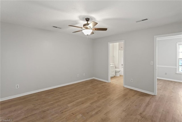 unfurnished bedroom with ensuite bath, light hardwood / wood-style flooring, and ceiling fan