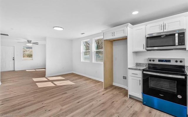 kitchen with light stone countertops, light hardwood / wood-style flooring, stainless steel appliances, and white cabinets