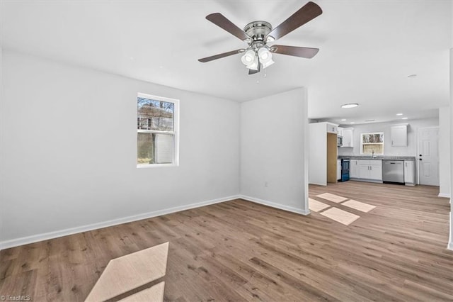 unfurnished living room featuring ceiling fan, sink, and light hardwood / wood-style flooring