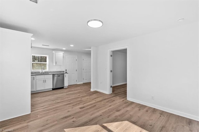 kitchen with white cabinetry, dishwasher, sink, and light hardwood / wood-style floors