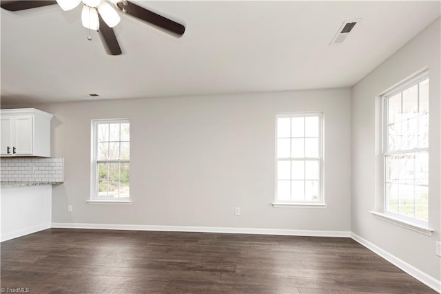 3217 N Ohenry Blvd, Greensboro, NC 27405 - unfurnished living room with plenty of natural light, visible vents, dark wood-style flooring, and ceiling fan