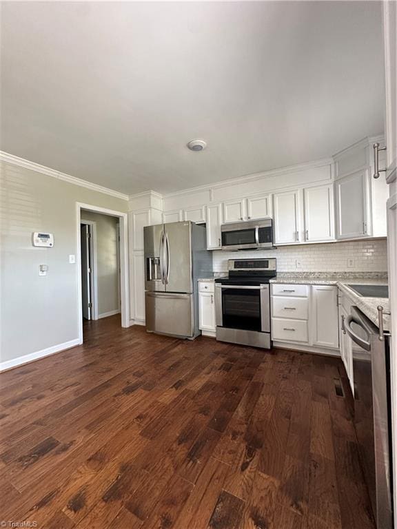 kitchen with white cabinets, decorative backsplash, ornamental molding, dark wood-style flooring, and stainless steel appliances